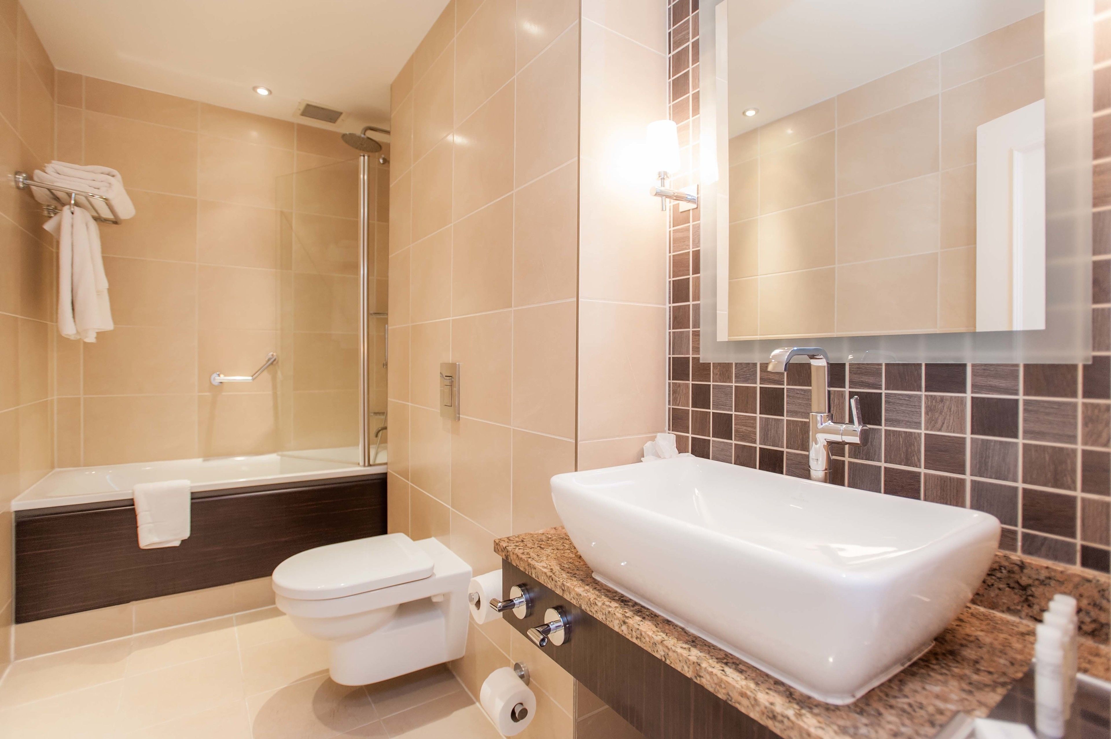 A modern bathroom with a bathtub, toilet, and sink.