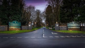 A road leading to Kingfisher Country Estate with stone walls and illuminated signs. - Doubletree by Hilton Belfast Templepatrick (Ballyclare)