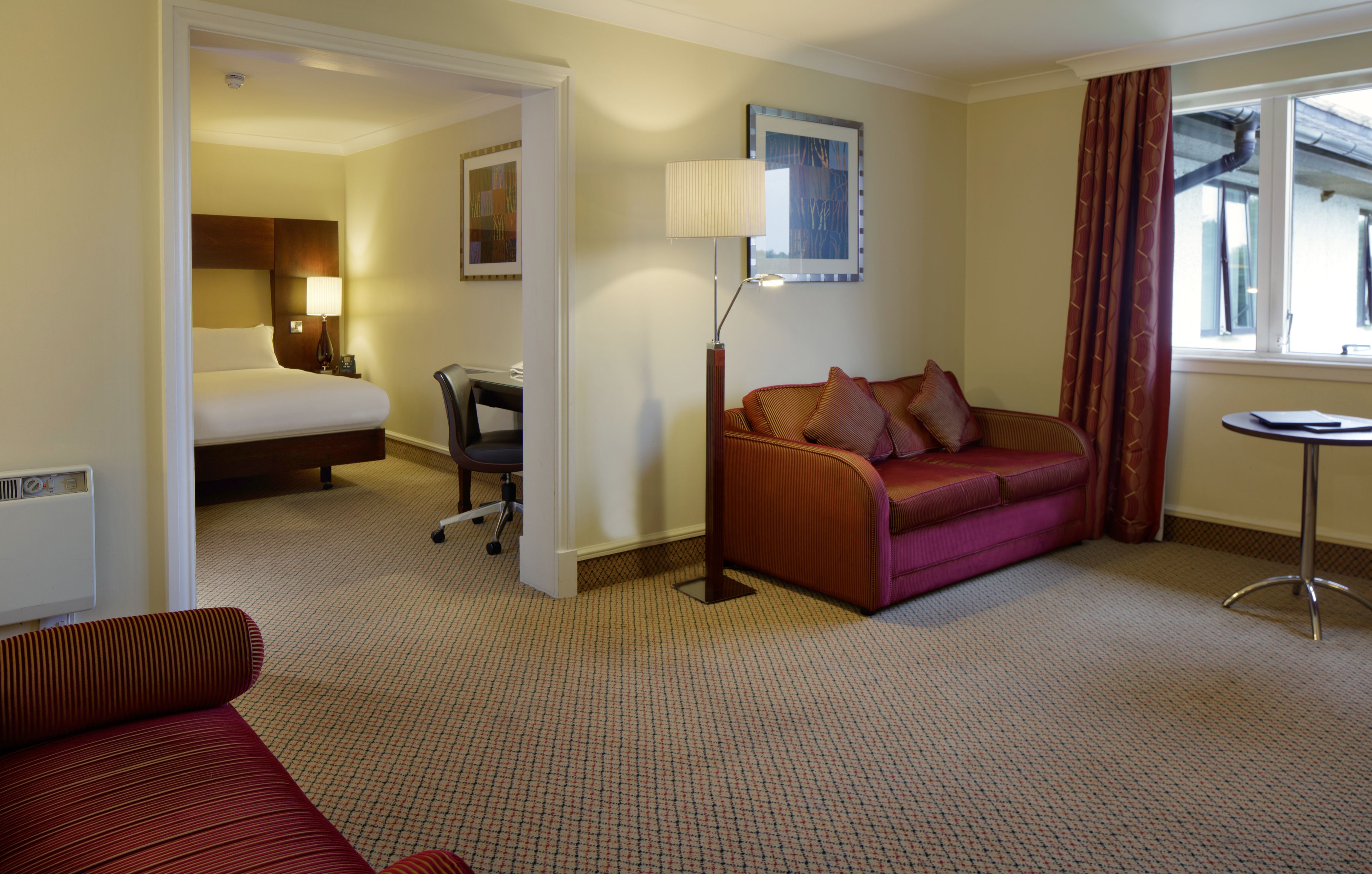 family room (deluxe) | in-room safe, desk, laptop workspace, blackout curtains