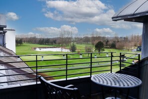 A balcony with a view of a golf course, a table, and chairs. - Doubletree by Hilton Belfast Templepatrick (Ballyclare)