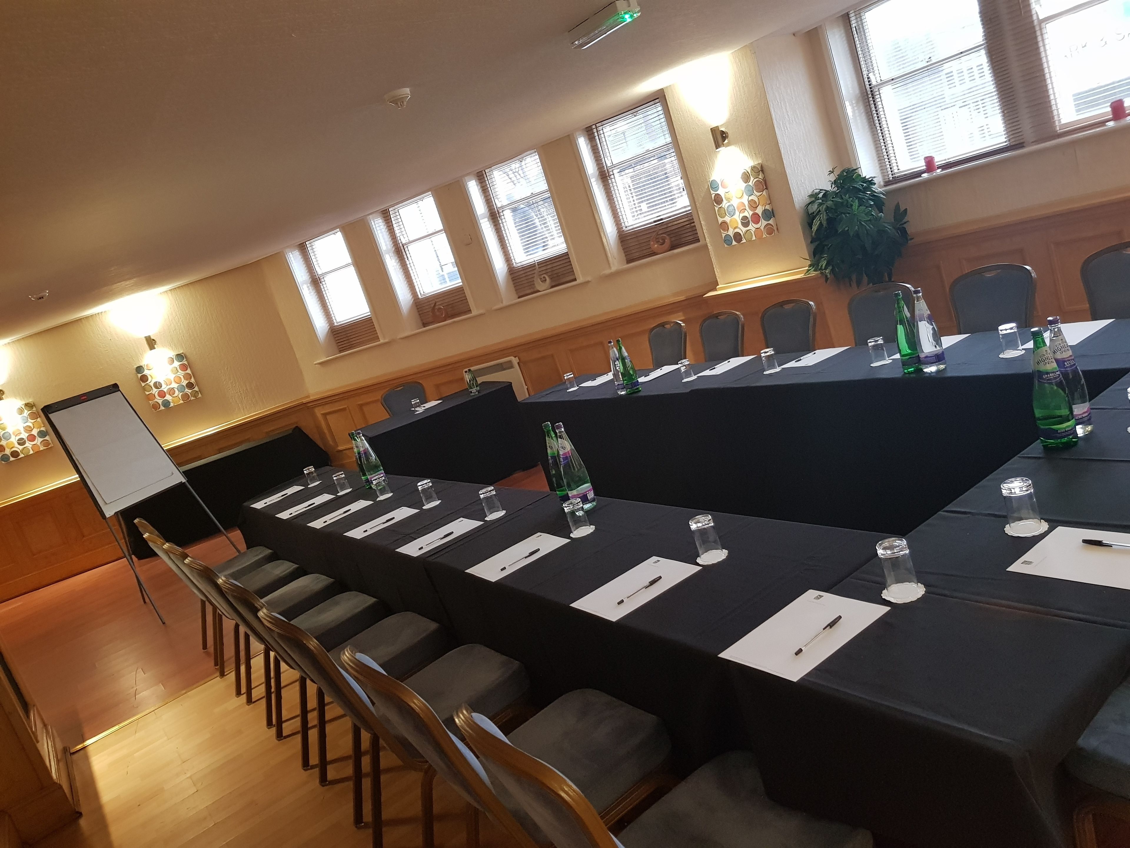 A conference room with a long table, chairs, and a whiteboard.