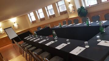 A conference room with a long table, chairs, and a whiteboard.