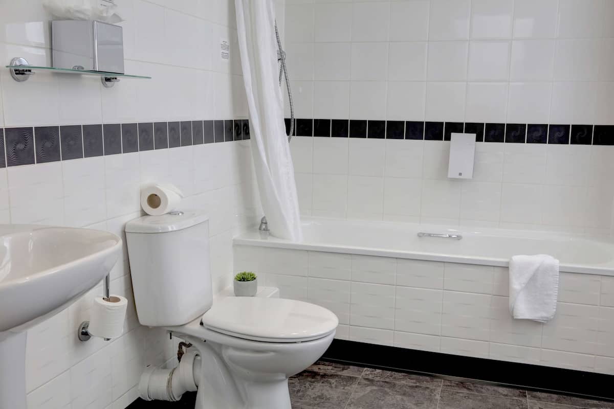 Kylpyhuone, jossa on wc, pesuallas ja kylpyamme.