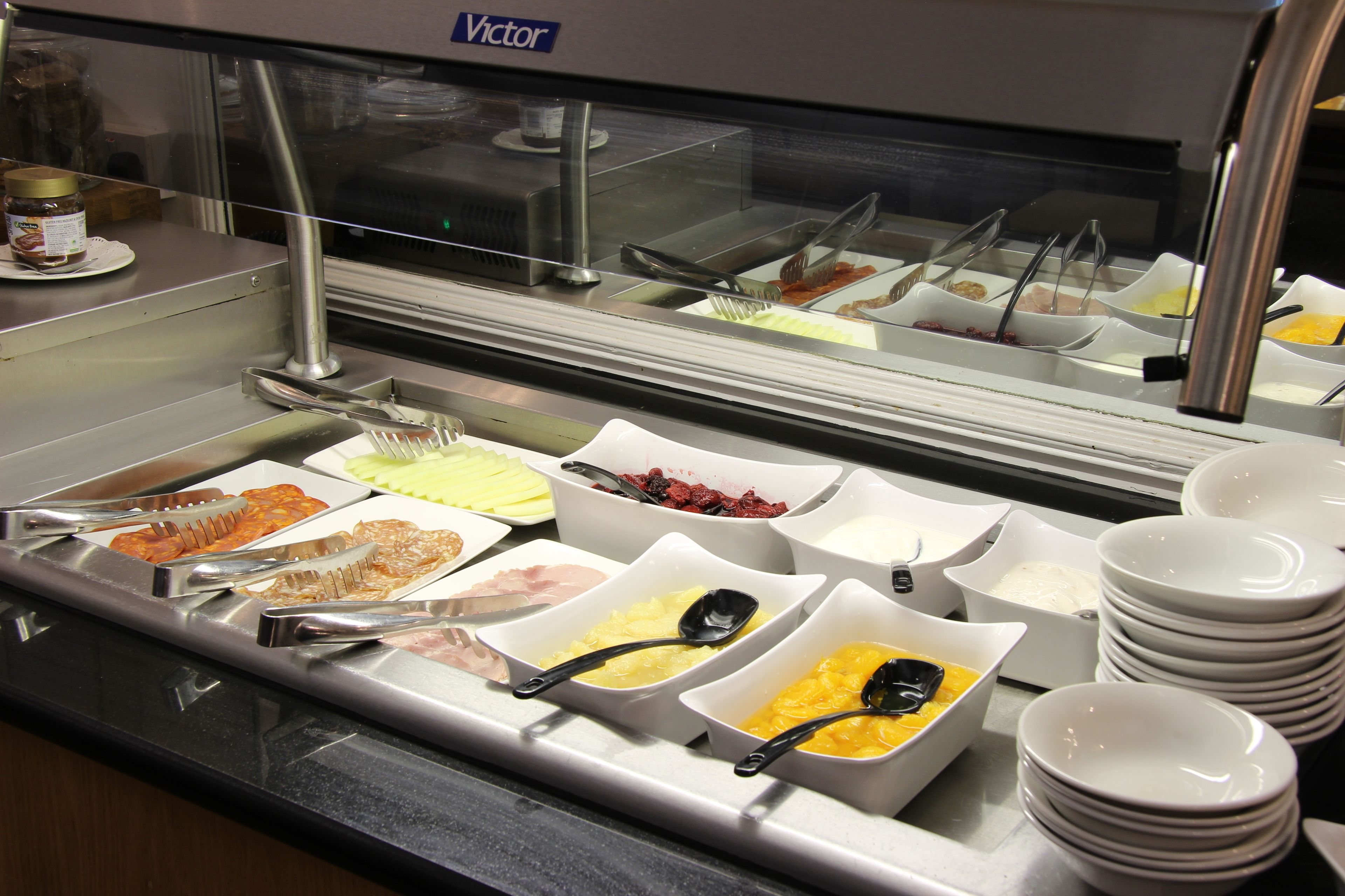 A buffet with various food items and serving utensils.