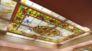 A ceiling with stained glass featuring floral patterns.