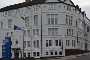 A white building with multiple windows and a sign indicating a public bar. - Best Western Stoke on Trent City Centre Hotel (Stoke-on-Trent)