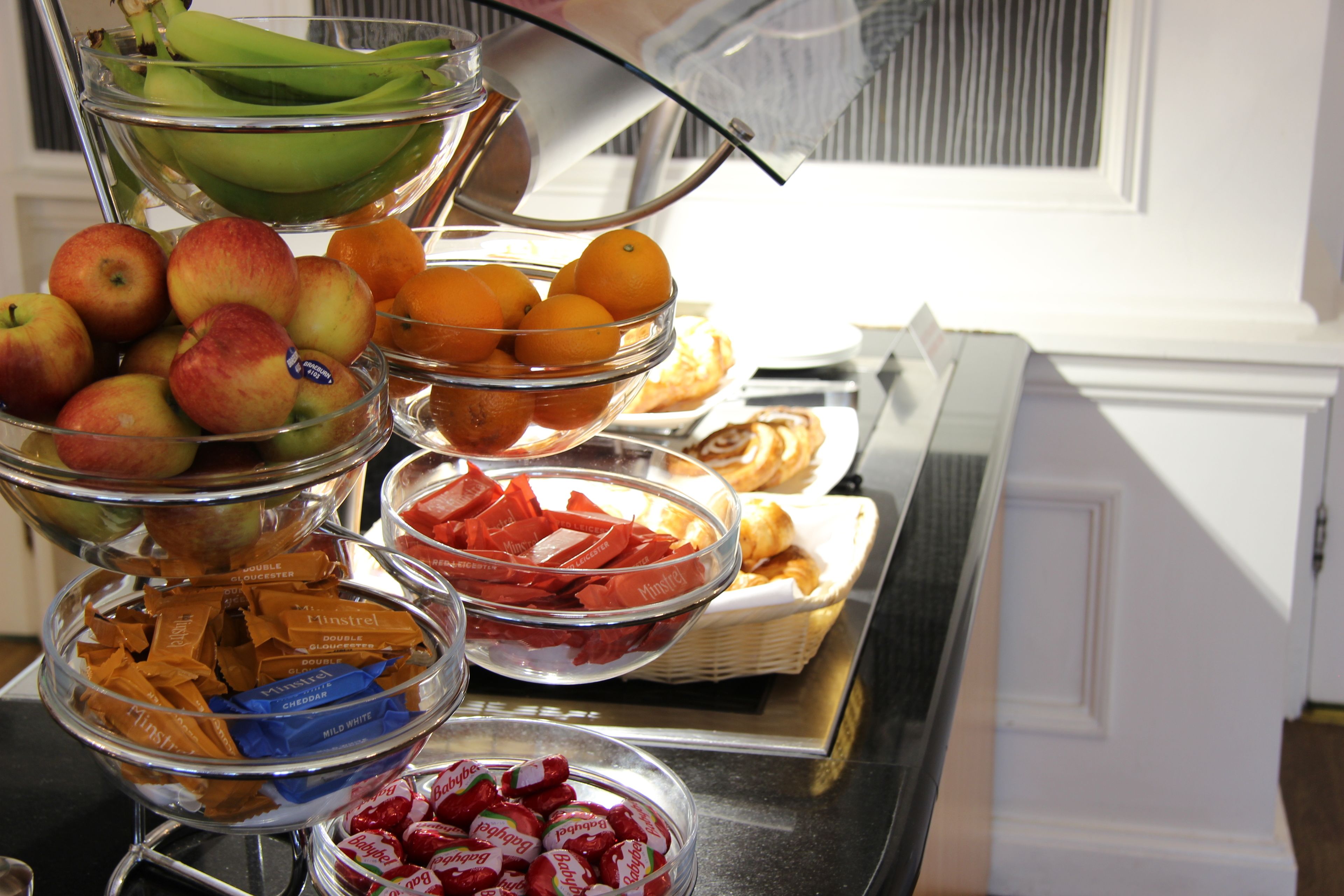 A buffet with various food items including fruits, pastries, and chocolates.
