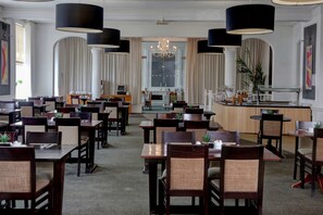 A spacious restaurant with multiple dining tables and chairs, large black pendant lights, and a central chandelier. - Best Western Stoke on Trent City Centre Hotel (Stoke-on-Trent)