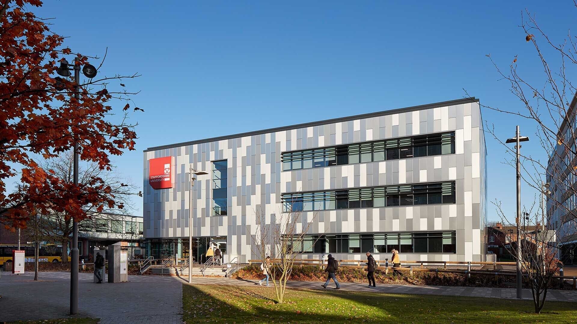 A modern building with a clear sign indicating it is a university.