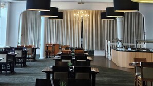 A hotel dining area with a chandelier, tables, chairs, and a counter. - Best Western Stoke on Trent City Centre Hotel (Stoke-on-Trent)