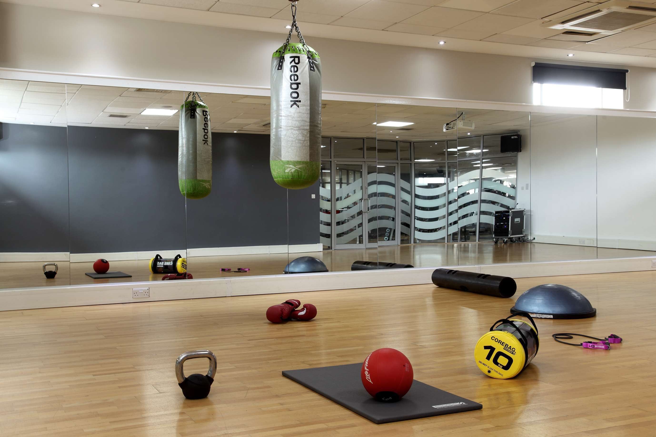 A gym with a punching bag, exercise balls, and a kettlebell.