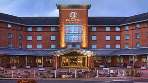 A DoubleTree by Hilton hotel with a brick facade, large windows, and a covered entrance area. - DoubleTree by Hilton Glasgow Strathclyde (Bellshill)