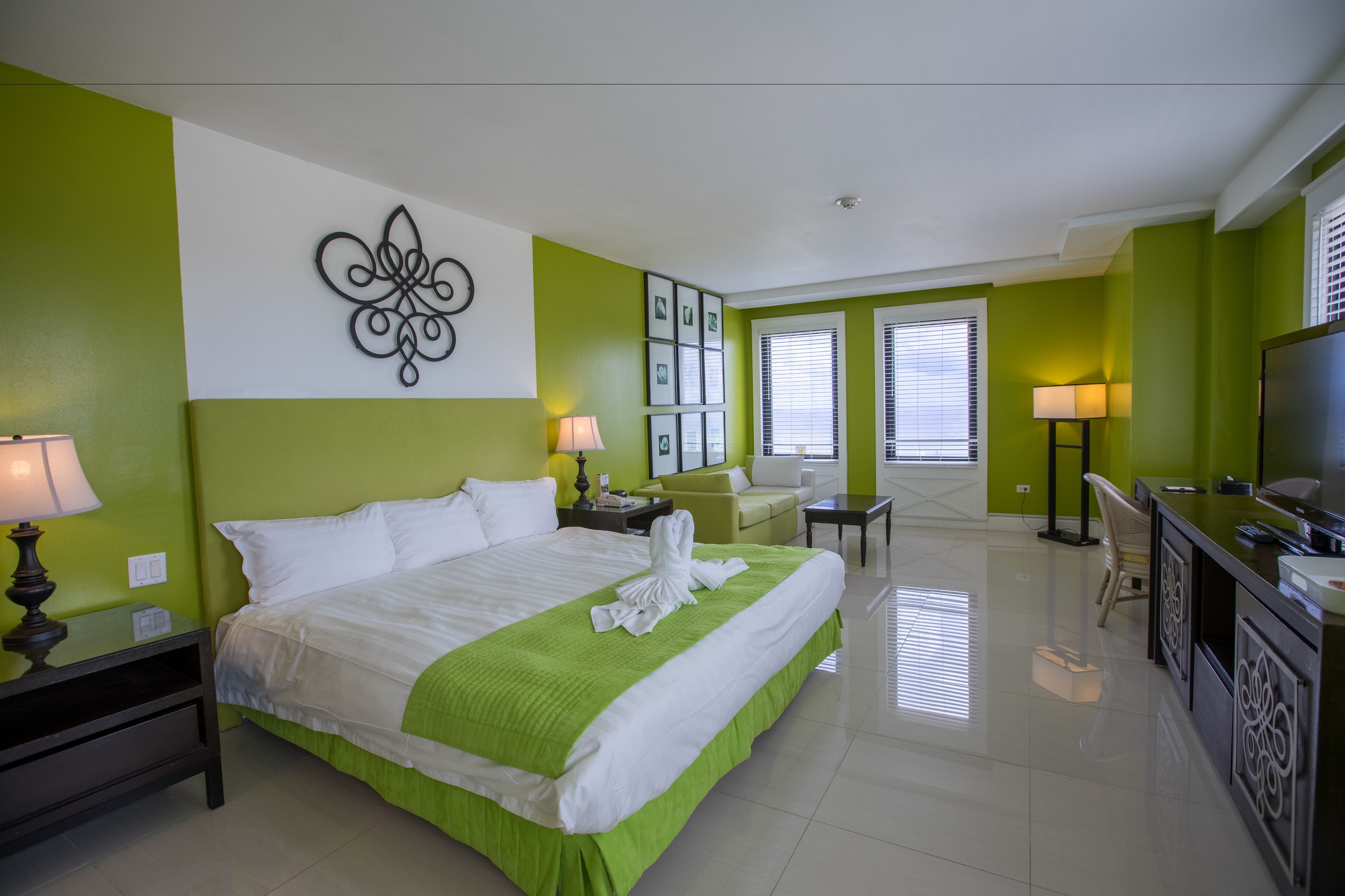 Habitación de hotel con una cama grande, un escritorio, una silla y una televisión.