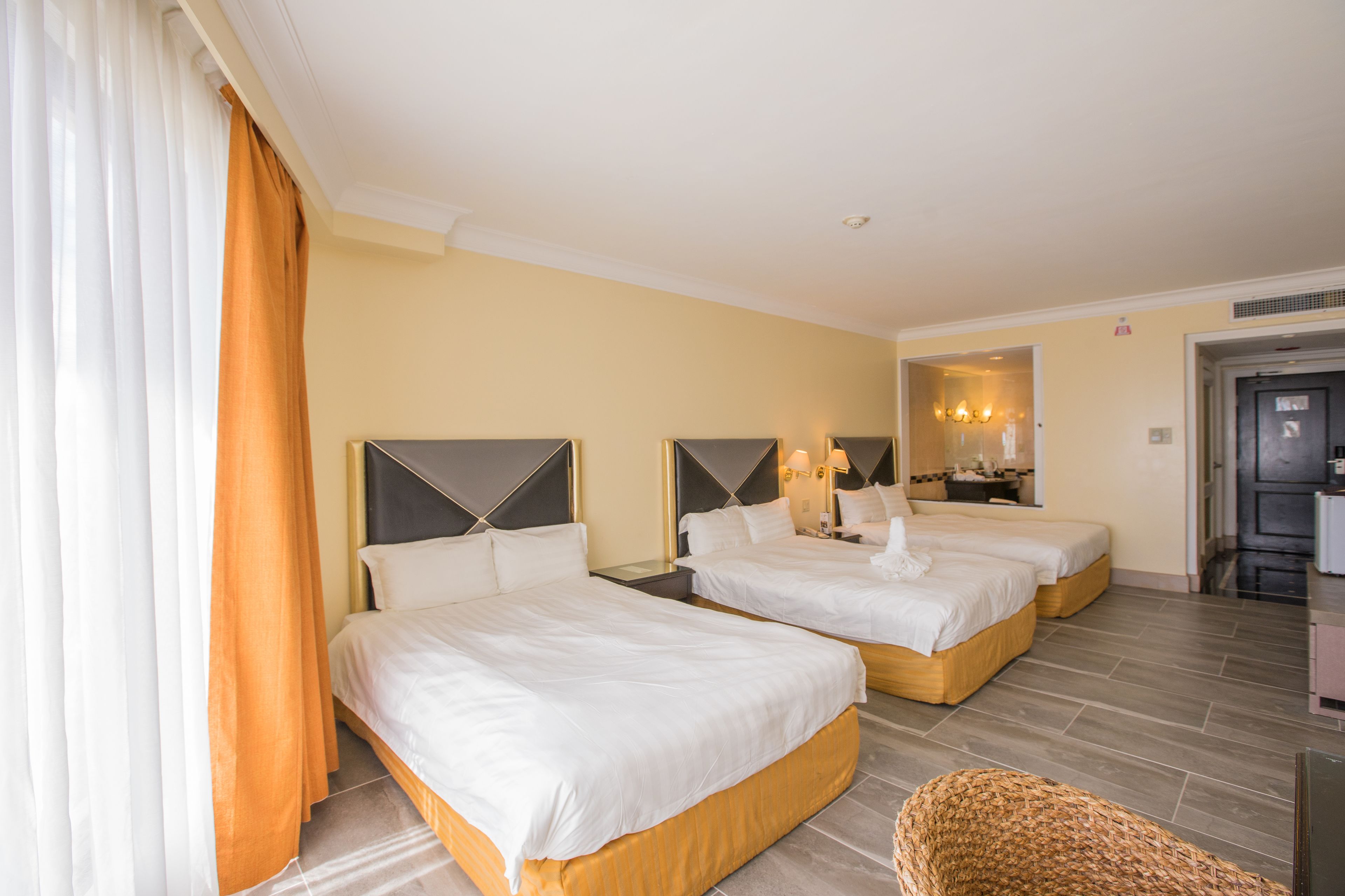 Une chambre d’hôtel avec deux lits, un petit coin salon et une kitchenette.