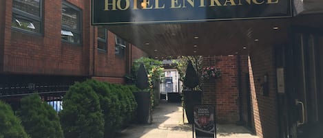 A hotel entrance with a sign featuring a lion emblem and the words "HOTEL ENTRANCE".