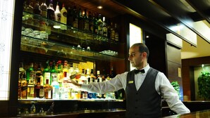 A bar area with shelves stocked with various bottles and glasses. - Casa D Or Hotel (Beirut)