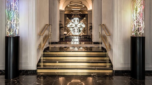 A grand staircase with a chandelier and modern light installations at the top. - Raffles Europejski Warsaw (Warsaw)