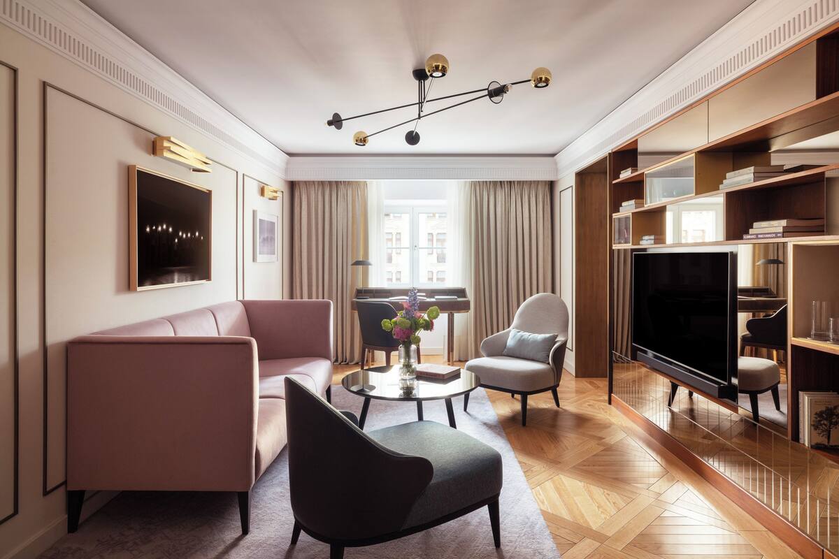 A modern living room with a sofa, armchair, coffee table, and a flat-screen TV.