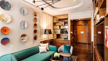 Un interior moderno con un sofá verde, dos sillones, una mesa de centro y una pared decorada con piezas de arte circulares.