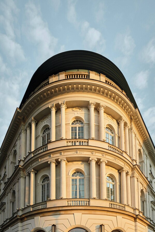 A classical building with a curved facade, columns, and arched windows.