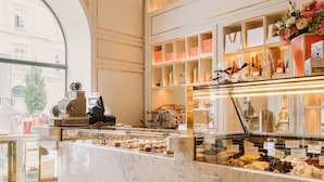 A luxurious interior with a marble counter, elegant chandeliers, and a view through a large window. - Raffles Europejski Warsaw (Warsaw)