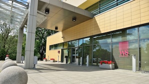 A modern building with a yellow facade, large glass windows, and a sign reading "WS WRESTLING". - Hotel Mercure Torun Centrum (Torun)