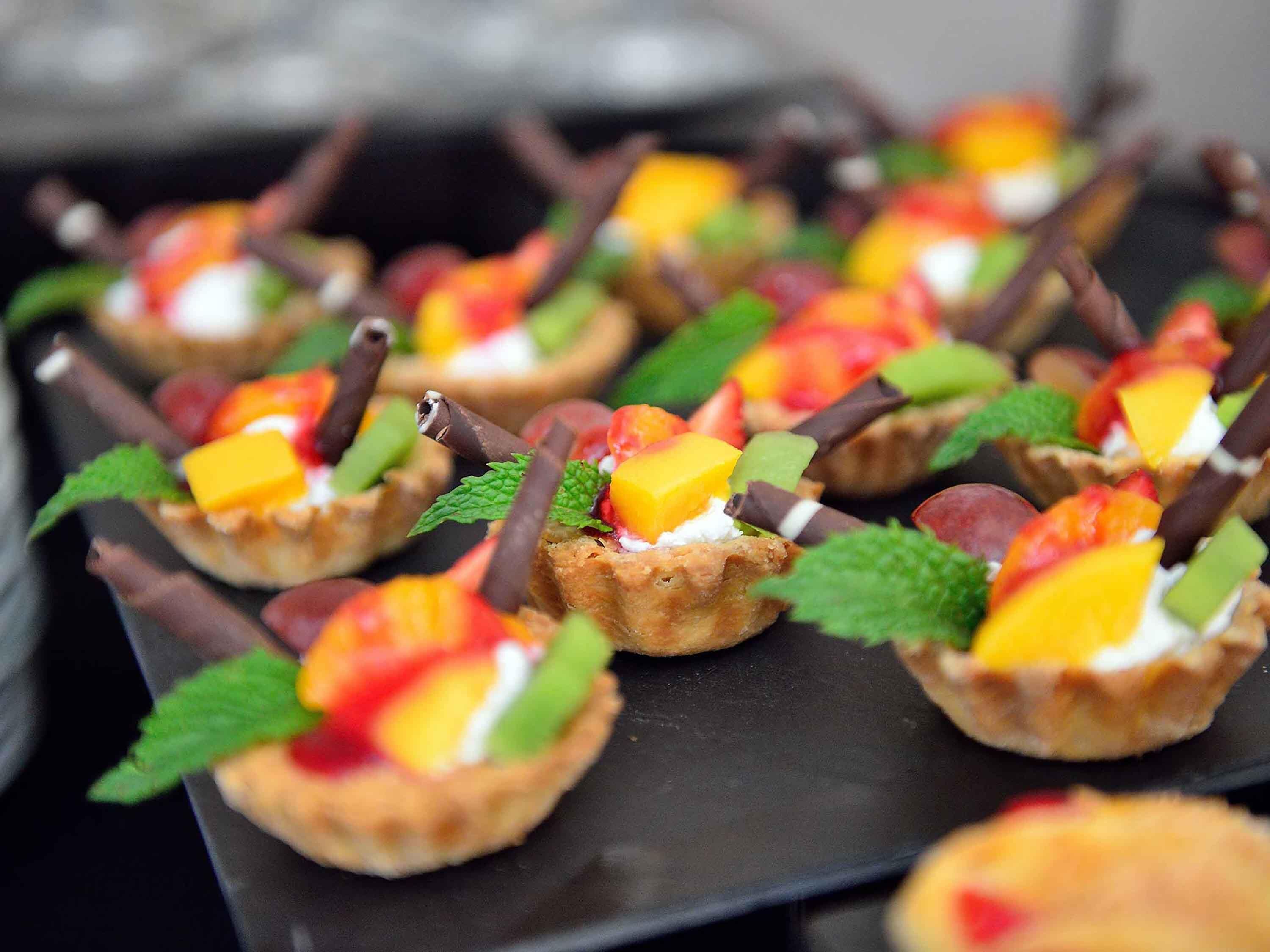 A dessert tray with fruit-topped tarts.