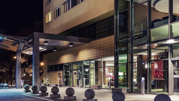 A modern building with a glass facade, a visible entrance, and a logo with 'WS' on the glass. - Hotel Mercure Torun Centrum (Torun)