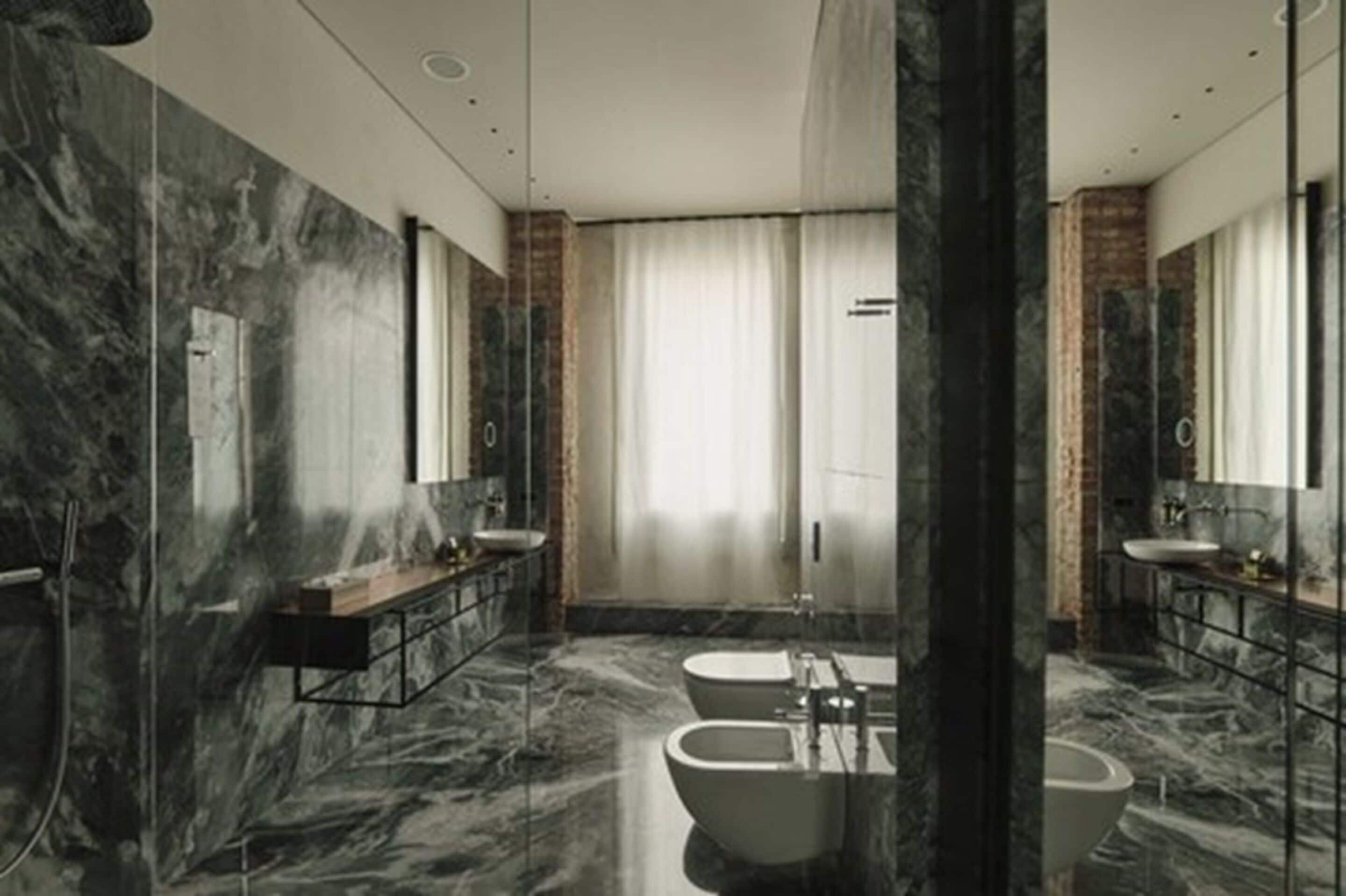 Une salle de bain moderne avec des murs en marbre, deux lavabos, une baignoire et un grand miroir.