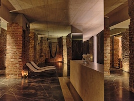 A spa area with a massage chair, a reception desk, and a brick wall.
