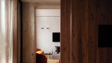 Un interior moderno con una puerta de madera, una mesa de vidrio y una silla roja.