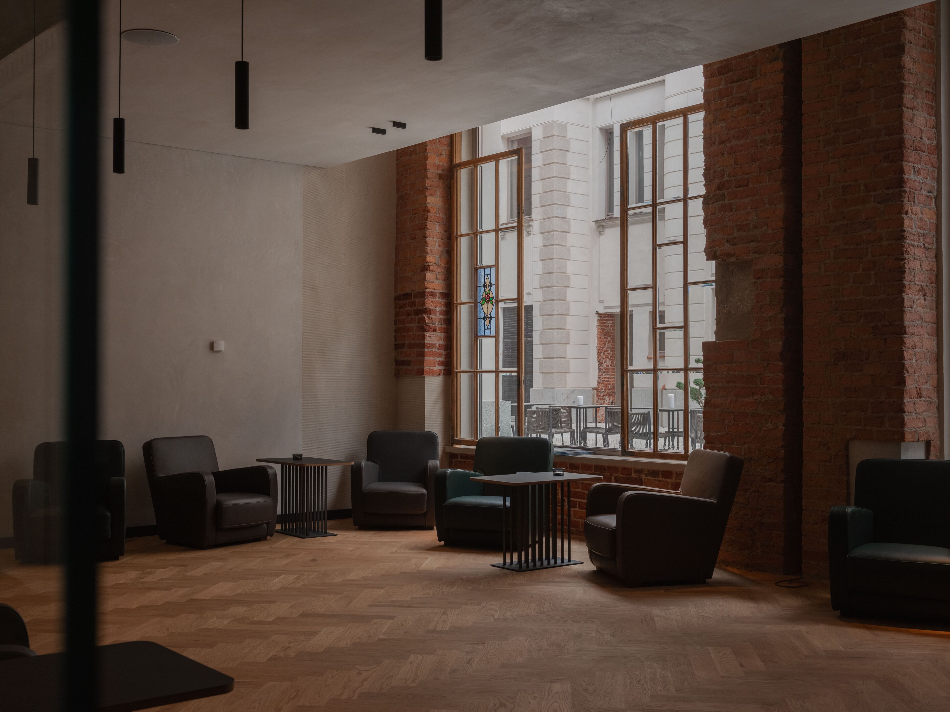 A modern interior with a brick wall, large windows, and contemporary furniture.