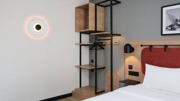 A modern hotel room with a bed, a wall-mounted shelf unit, and a circular light fixture.