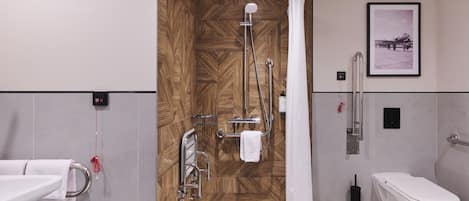 Un baño moderno con ducha, inodoro y lavamanos, que presenta un panel de pared de madera y un cuadro enmarcado.