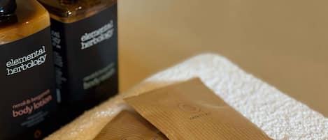 Une serviette, deux capuchons de douche en bois et un flacon de lotion pour le corps.