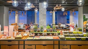 Uma área de buffet com diversos alimentos e um pilar decorativo central.