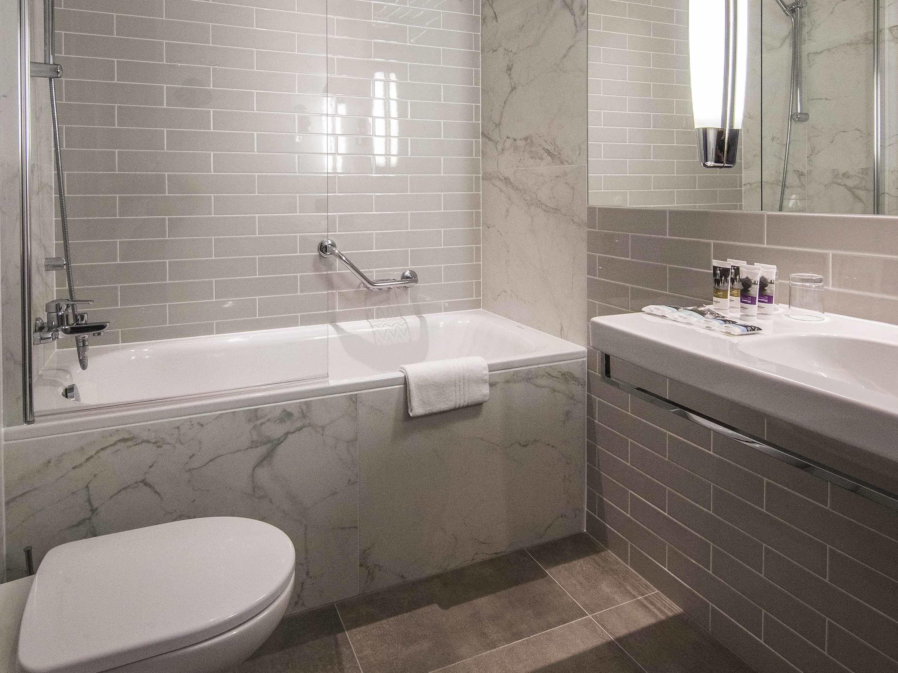 A modern bathroom with a bathtub, toilet, and sink.