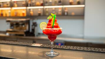 Ein Cocktail mit Limettenspalte und Minzzierde auf einer Bar.