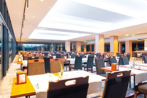 Dine in style with a high ceiling and elegant table settings.