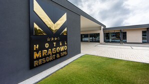 Un letrero moderno de hotel con un diseño geométrico y el nombre "HOTEL MRAGOWO RESORT & SPA".