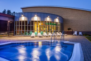 Relax by the pool surrounded by lounge chairs and a hot tub.