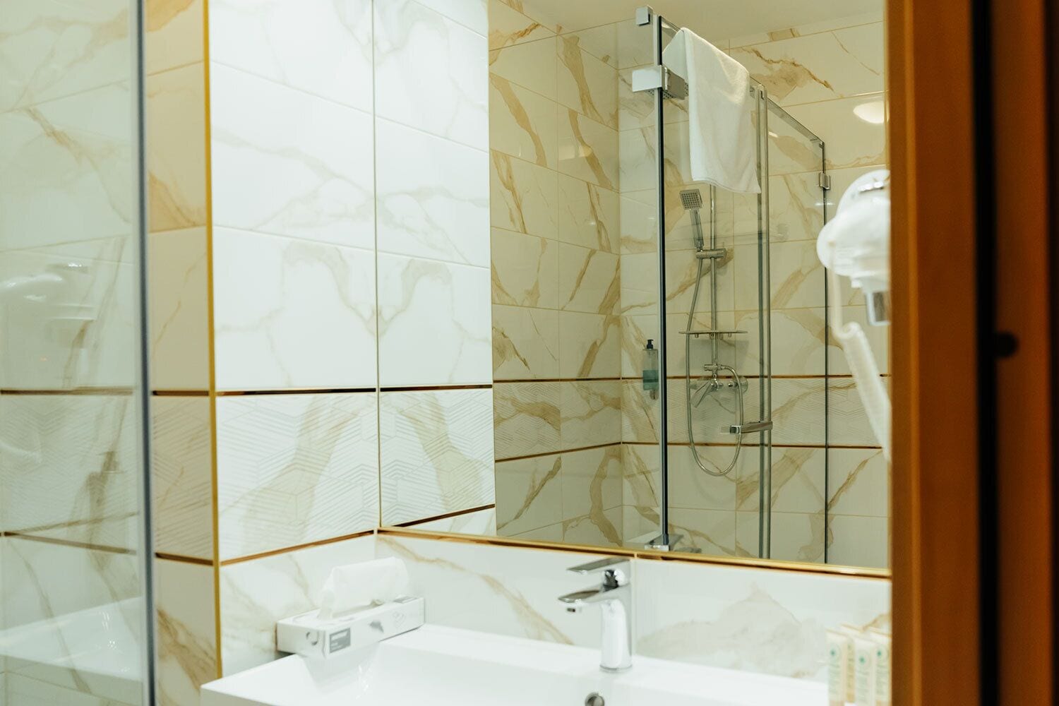 A bathroom with a shower, a sink, and a mirror.