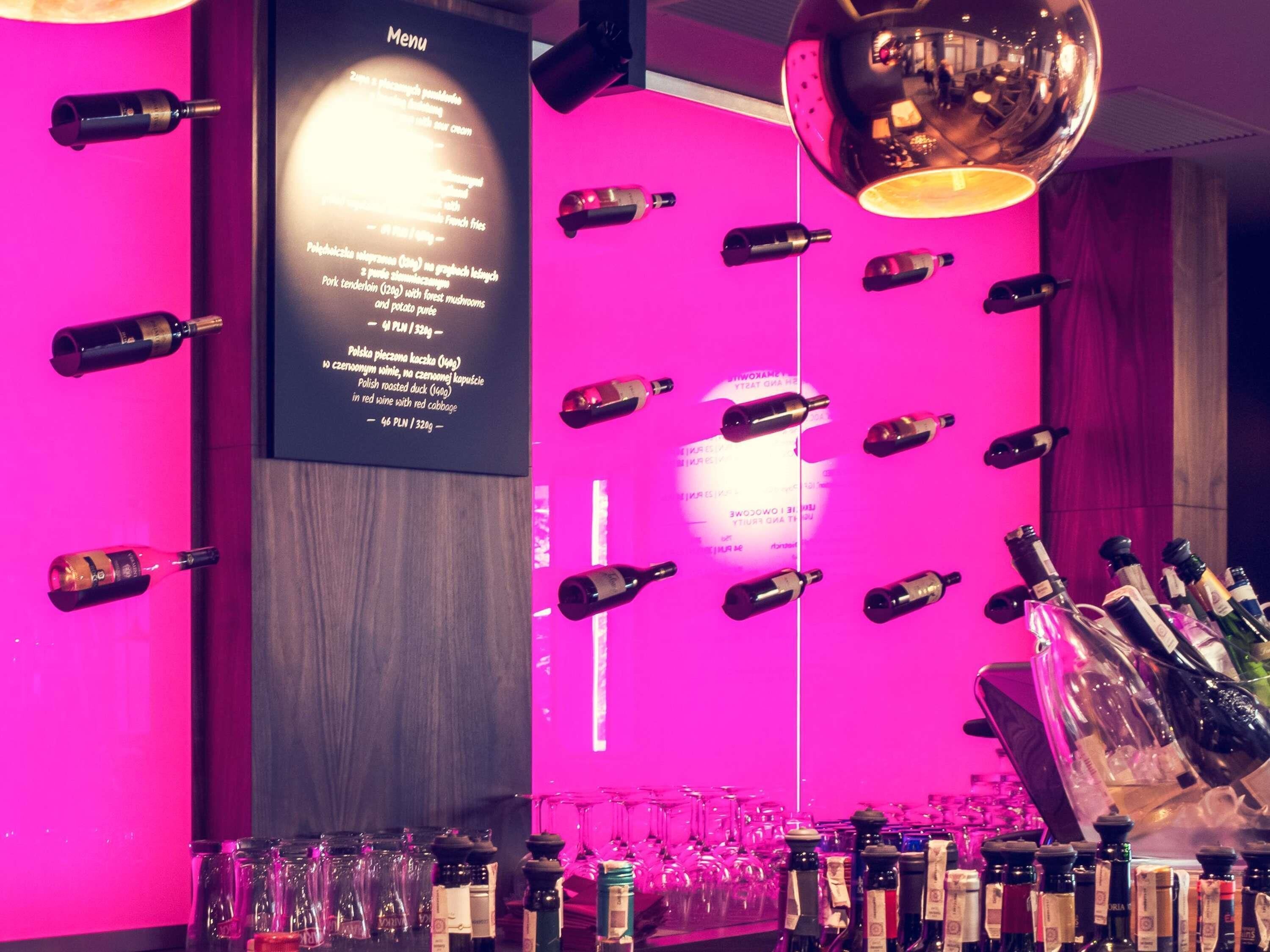A bar area with bottles and glasses, a menu, and a mirror.