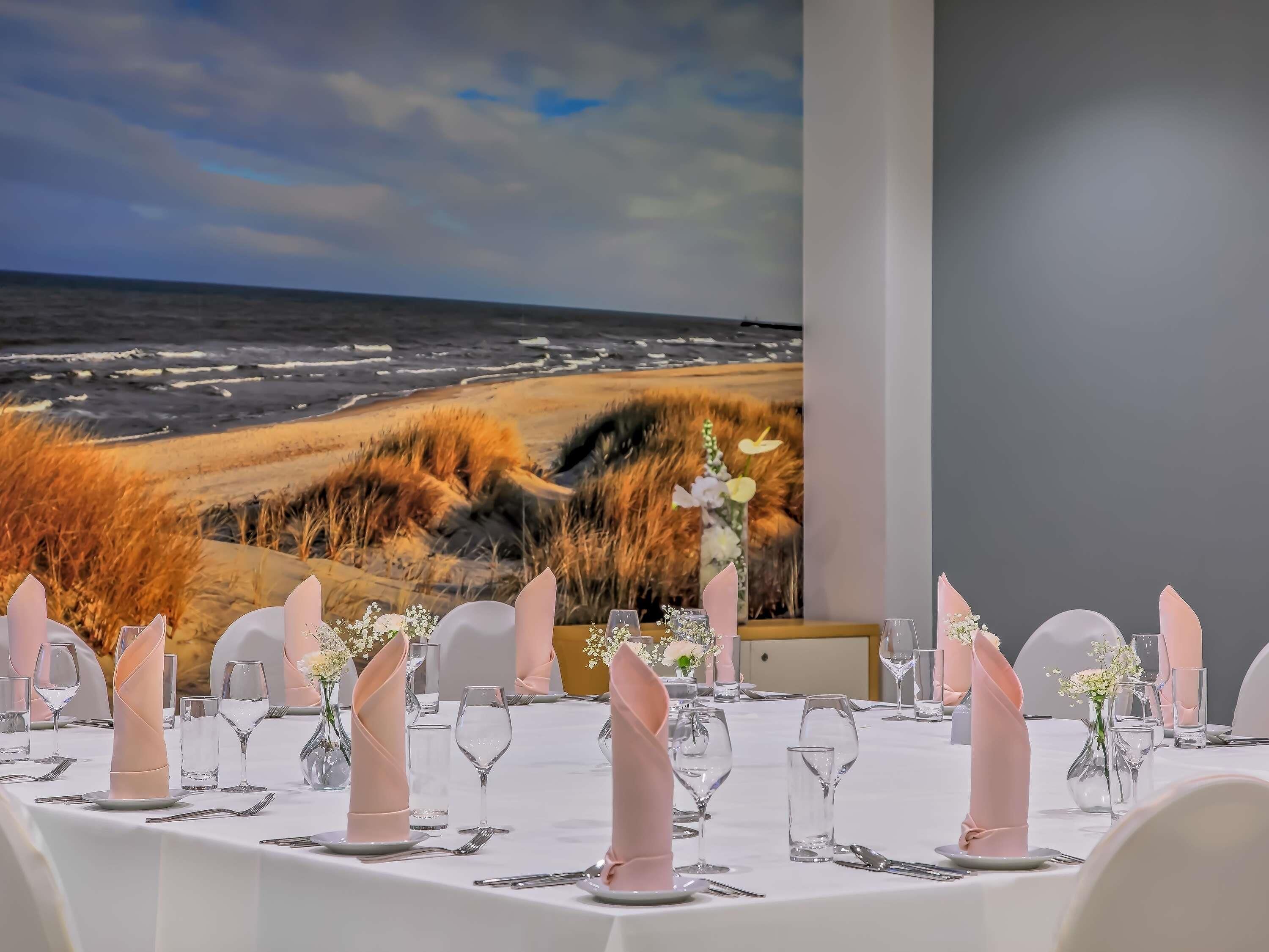 Mesa lista para comer con vista a la playa y las dunas.