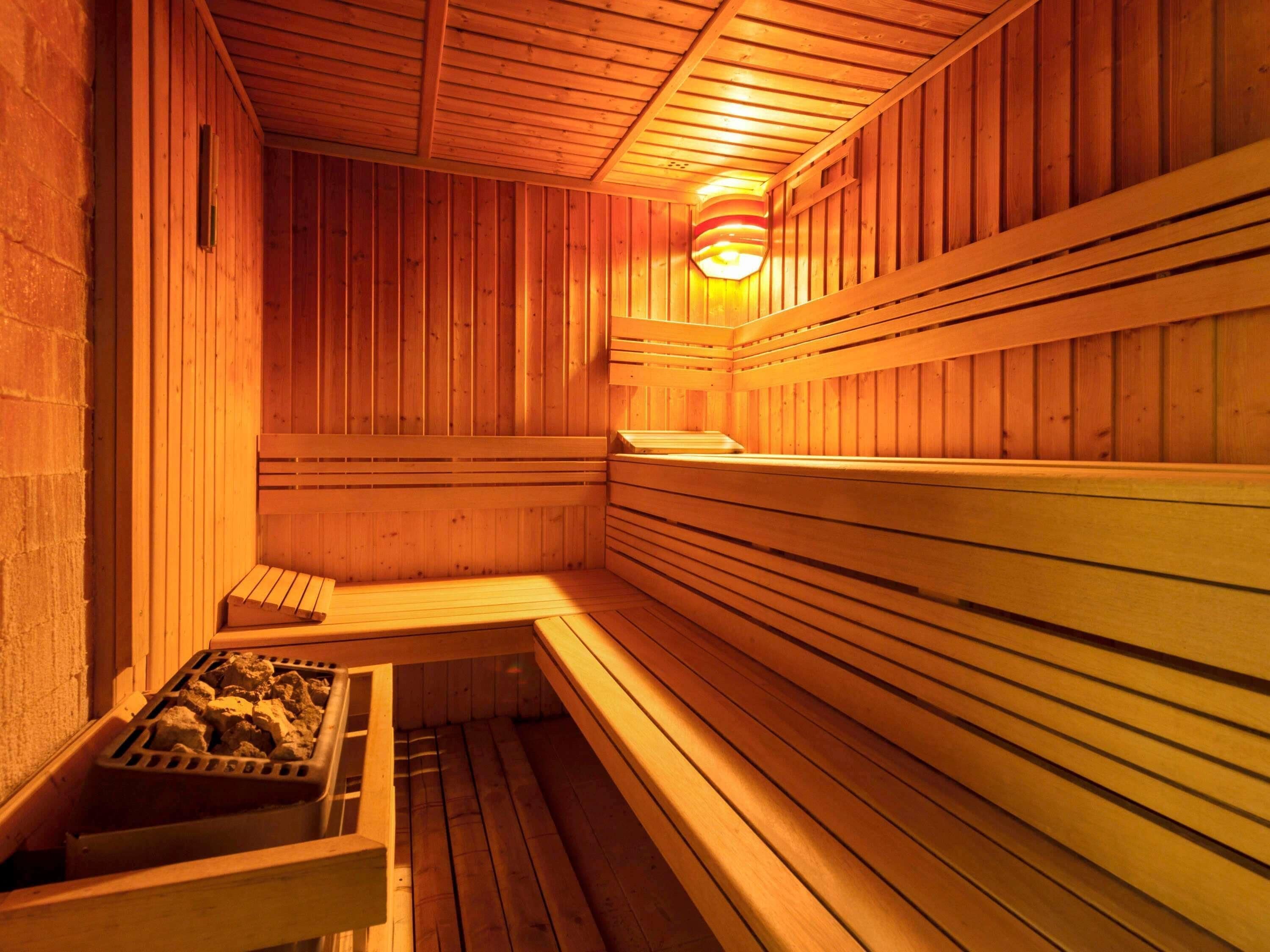 A sauna with wooden benches and a stone bench.