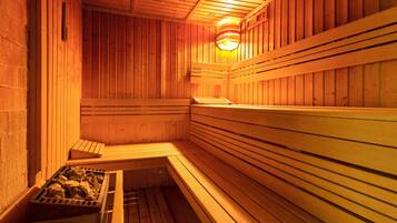 Una sauna con bancos de madera y un banco de piedra.