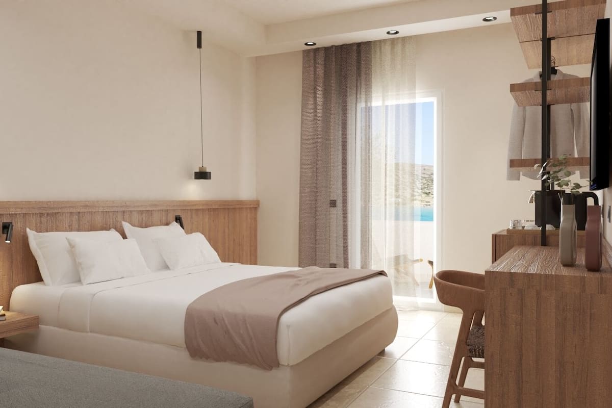 A modern hotel room with a large bed, a desk, and a TV.