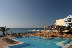 Relax by the pool with a clear view of the sea, surrounded by sun loungers and umbrellas.