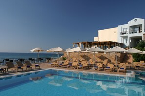 Relax by the pool with ocean views, surrounded by comfortable loungers and shaded by umbrellas.