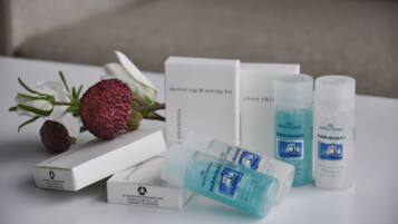 Conjunto de produtos de higiene pessoal, incluindo touca de banho, kit de costura, kit de limpeza de sapatos e duas garrafas de shampoo Karavaki.